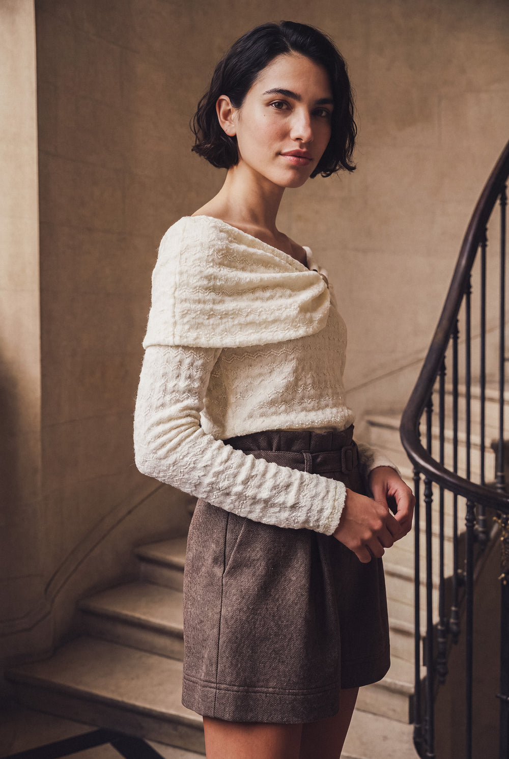 Top en dentelle à col bateau et short en laine chinée dans un escalier de marbre, collection Entre deux étages